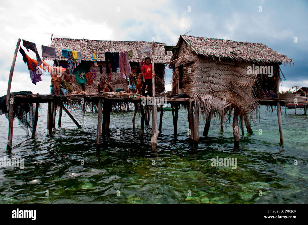 the family members outside their floating hut in Semporna Island in Sabah Apr 22 2013 Stock Photo