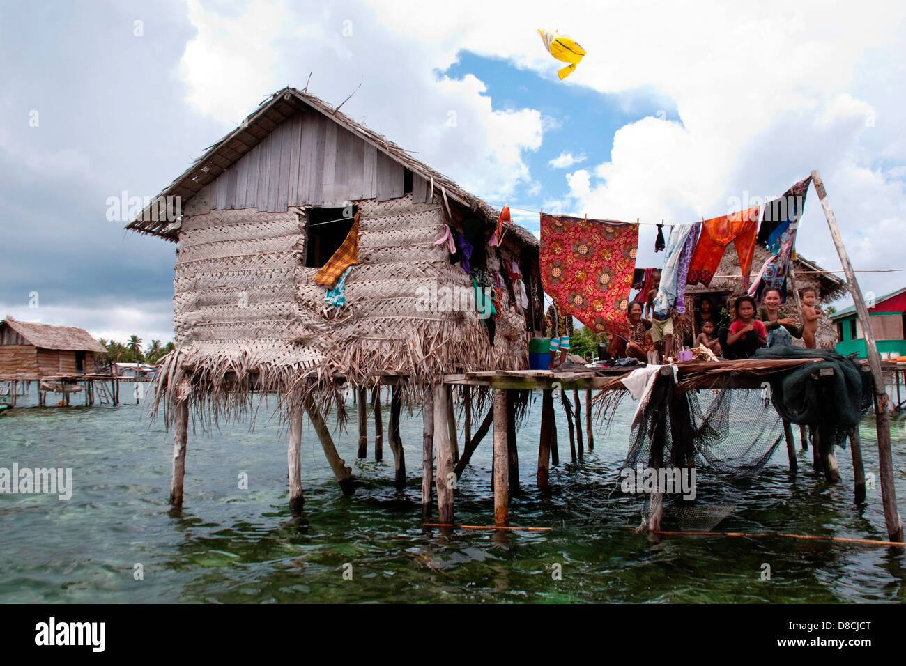 all the family members sitting in front of their floating hut in Semporna Sabah on Apr 22 2013 Stock Photo