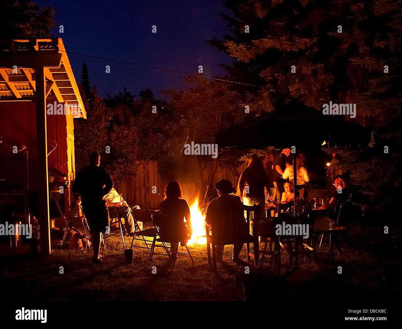 A fire burning brightly at night, with the flames visible against the dark backdrop. The image captures the intensity and warmth of the fire as it illuminates the surrounding area, creating a contrast between light and darkness. Stock Photo