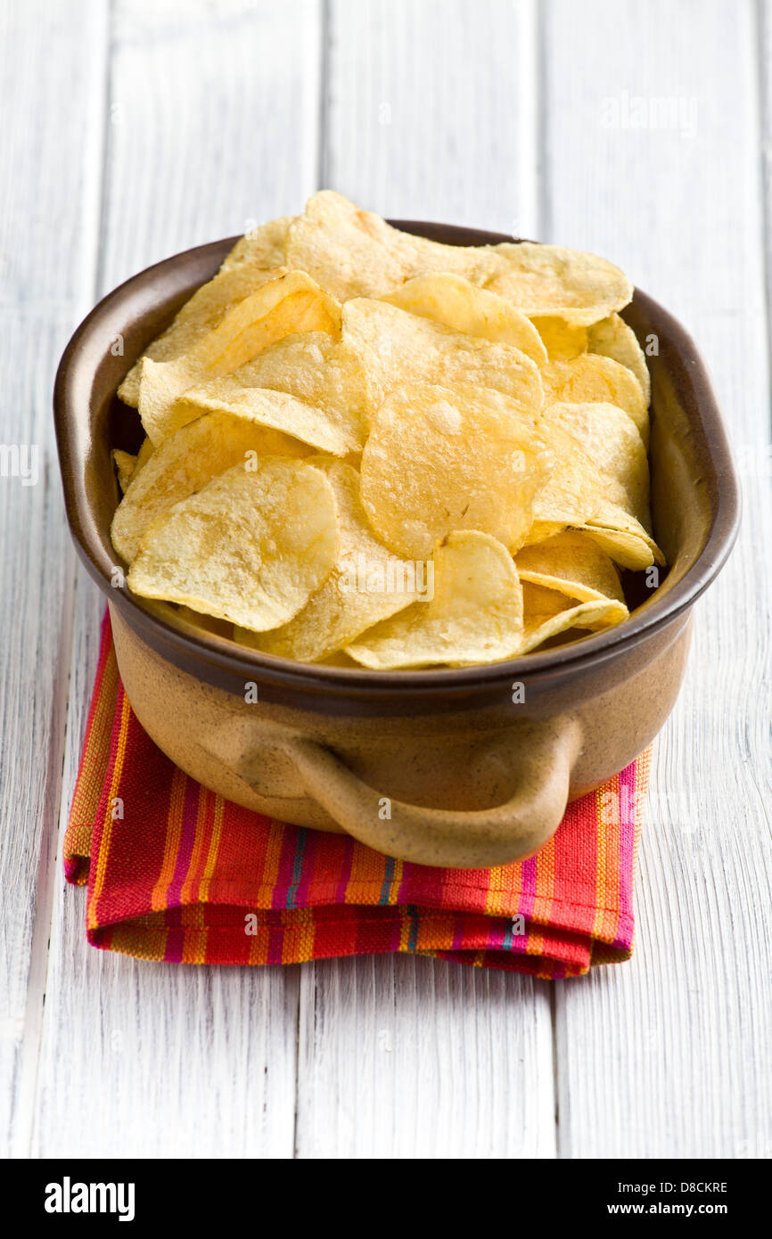 crispy potato chips on wooden table Stock Photo