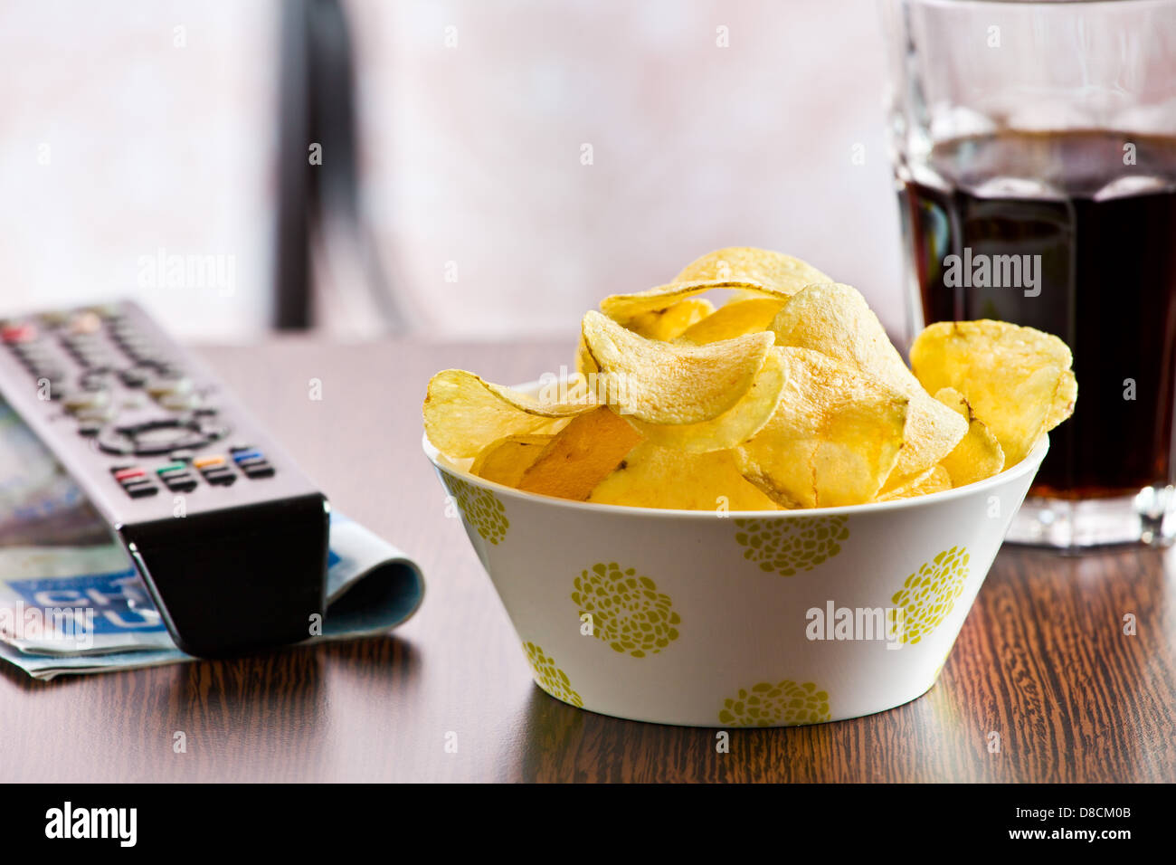 the crispy potato chips and remote control Stock Photo