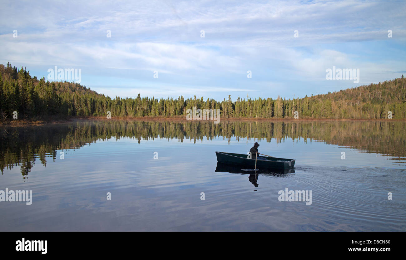 man rowing on a calm wild lake Stock Photo