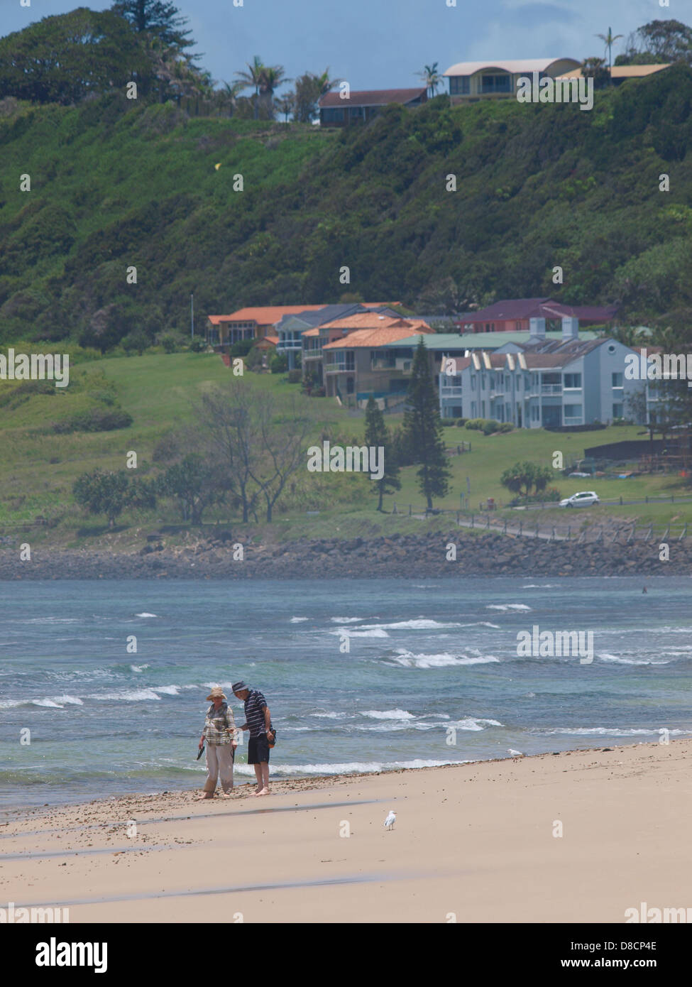 COUPLE WALKING ON BEACH LENNOX HEAD, NEW SOUTH WALES AUSTRALIA Stock Photo