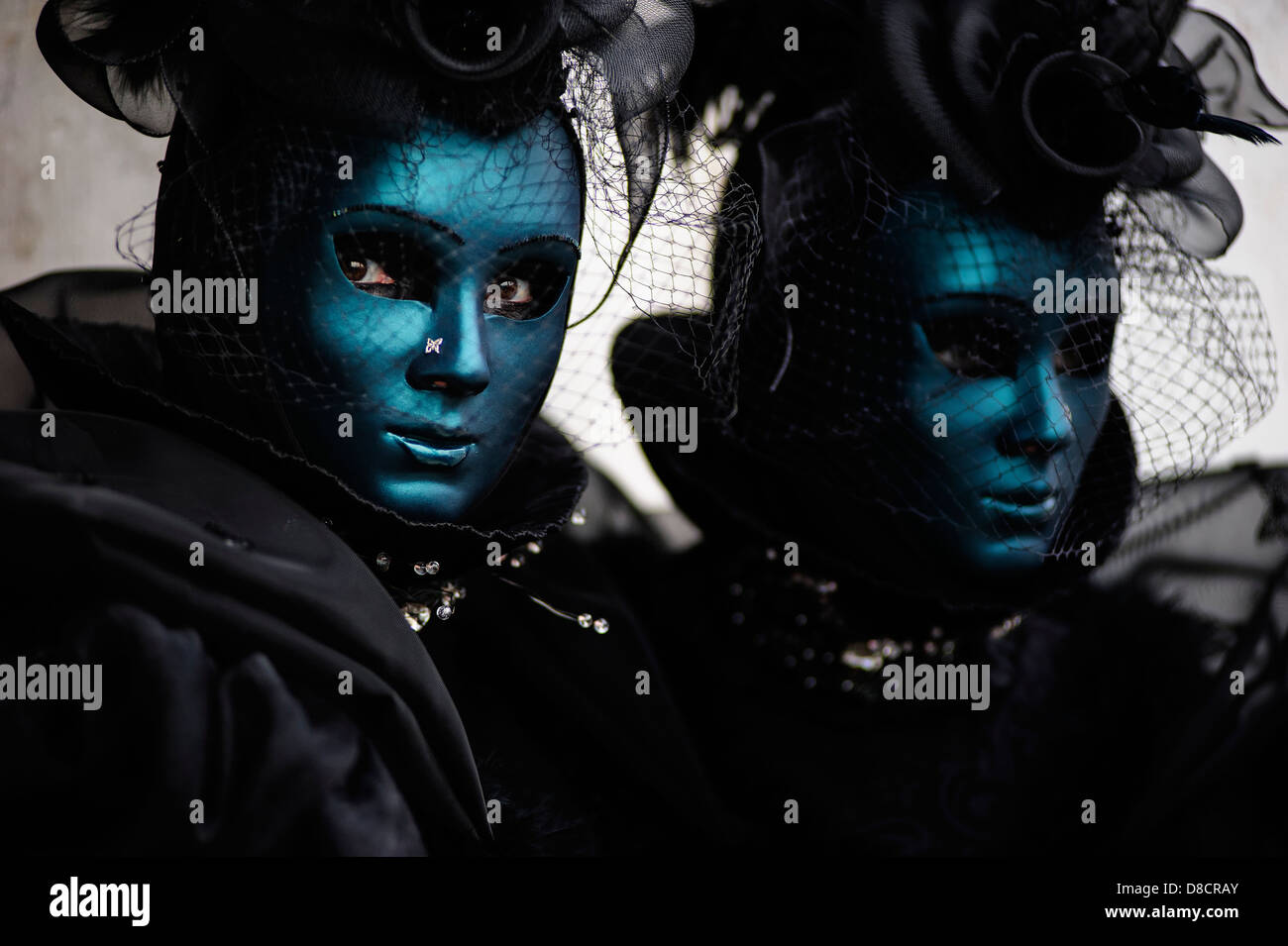 Two women wearing dark carnival costumes and masks during the Carnival, Italy Stock