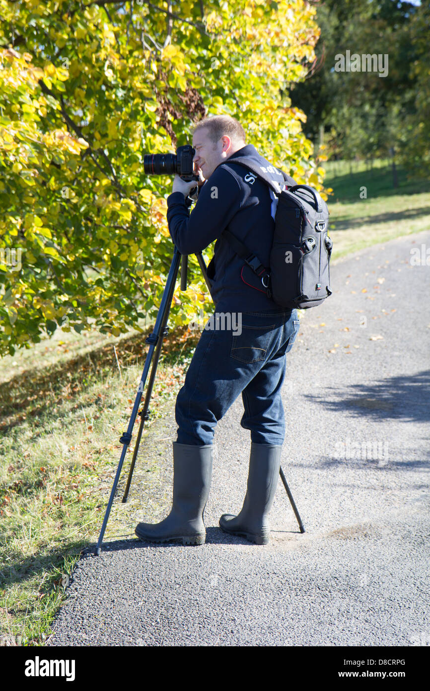 Camera Man Taking a Photo Picture with a tripod rucksack model lifestyle photograph Stock Photo