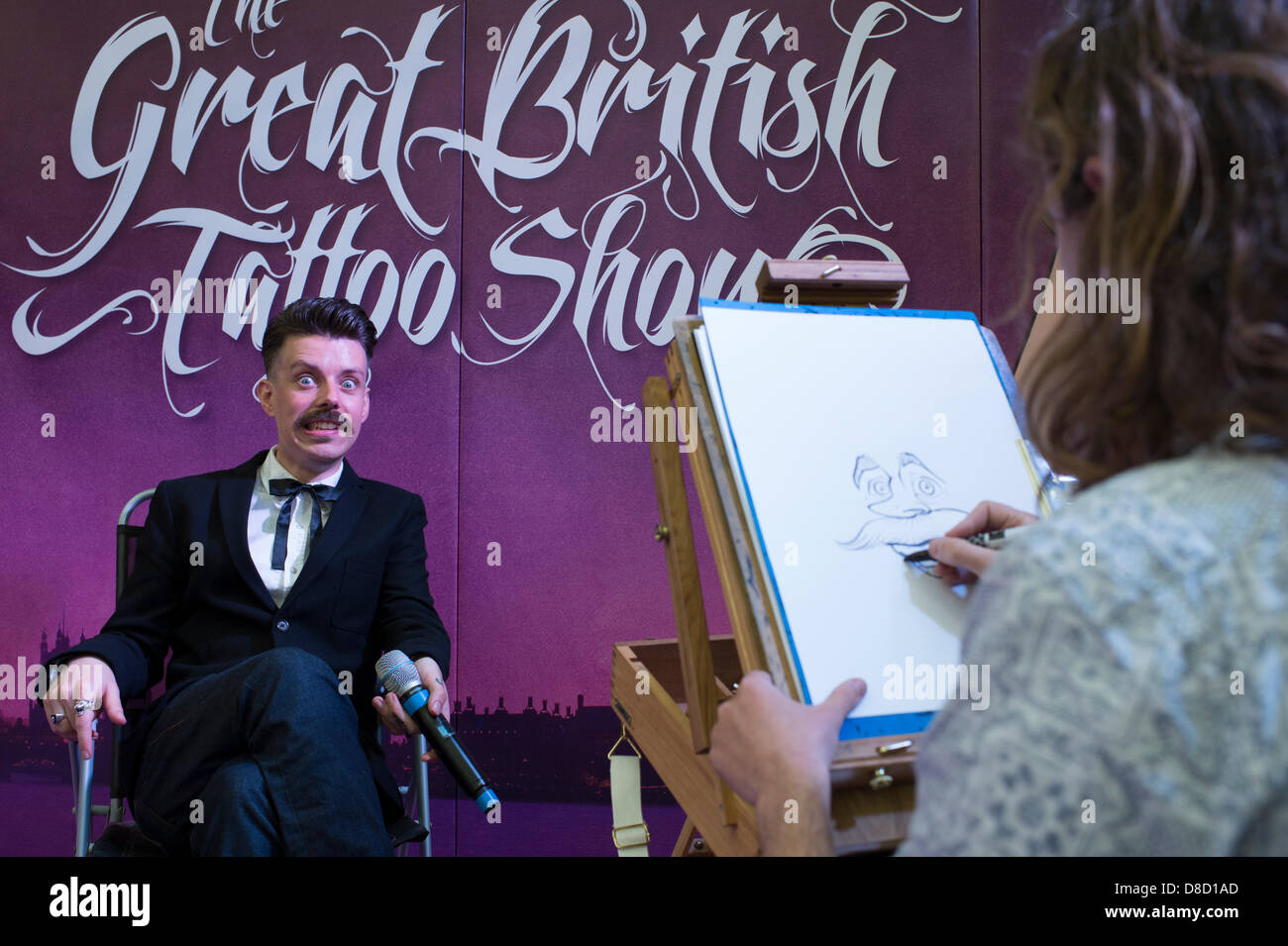 Caricature artist, Jon-Paul, draws compare, Paul Sweeney, at The Great British Tattoo Show, London. Credit: Allsorts Stock Photo/Alamy Live News Stock Photo