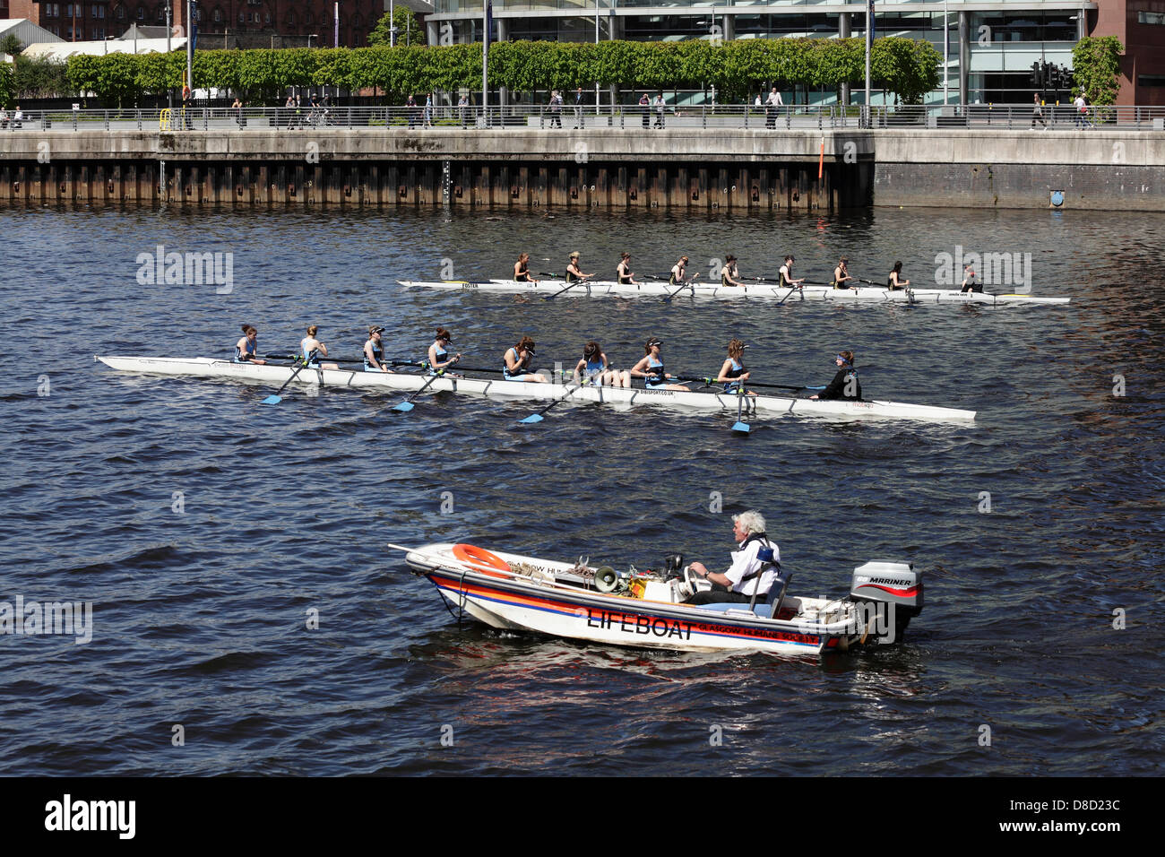 Glasgow, Scotland, UK, Saturday, 25th May, 2013. Participants line up at the start of the 1st VIII female Scottish Boat Race between the University of Glasgow in black vests and University of Edinburgh in blue vests on the River Clyde at the Broomielaw in the city centre Stock Photo