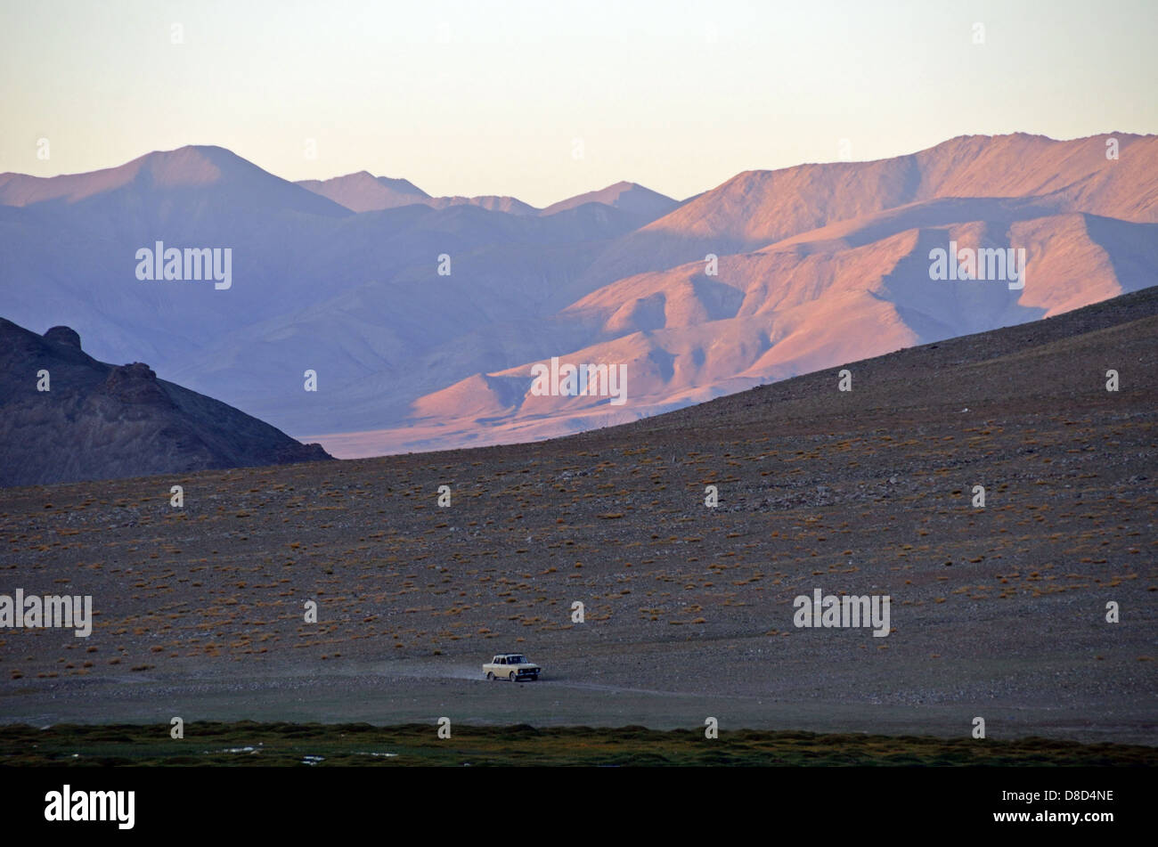 Lada driving at sunset in the Pamir Mountains Stock Photo