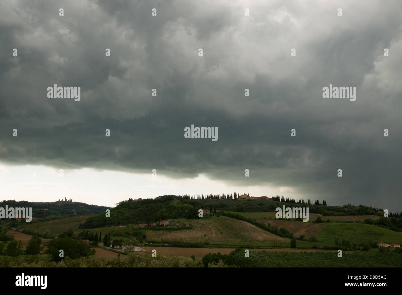 Thundery clouds over a extensive hilly landscape of Tuscany with Medieval hilltop town of San Gimignano, Tuscany, Italy, Europe Stock Photo