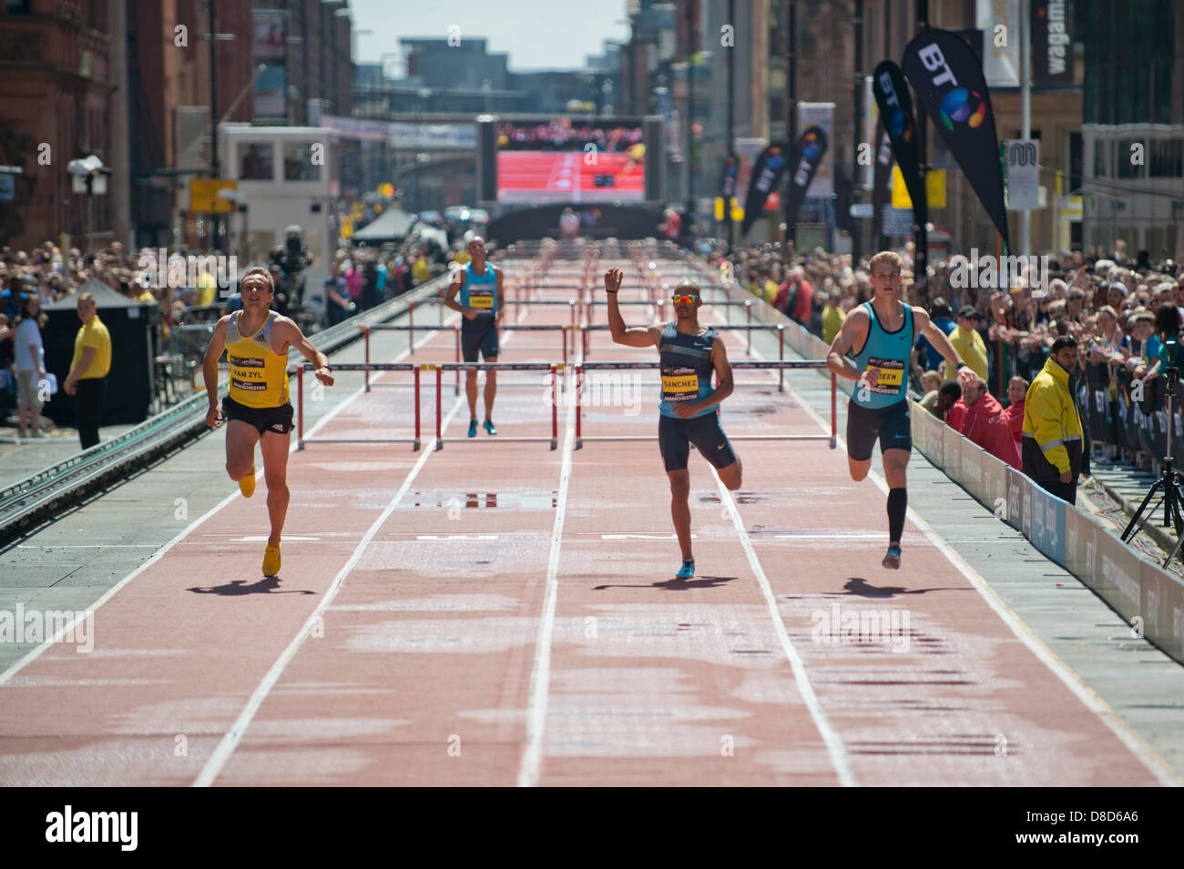 MANCHESTER, UK. 25th May 2013. Louis Jacob van Zyl (furthest left) of South Africa sprints to take 1st place during the Mens 200m Hurdles event in a time of 22.63 which took place on Deansgate in Manchester during the 2013 BT Great CityGames. He beat Jack Green (Great Britain, 2nd, furthest right), Felix Sanchez (Dominican Republic, 3rd, second right) and Andy Turner (Great Britain, DNF, second left). Credit: News Shots North/Alamy Live News (Editorial use only). Stock Photo