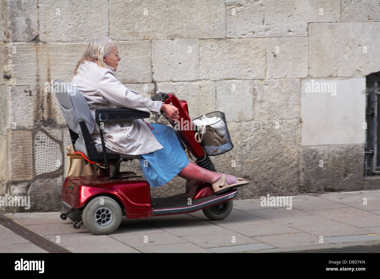 pensioner riding mobility scooter along pavement at Oxford, Oxfordshire UK in May Stock Photo