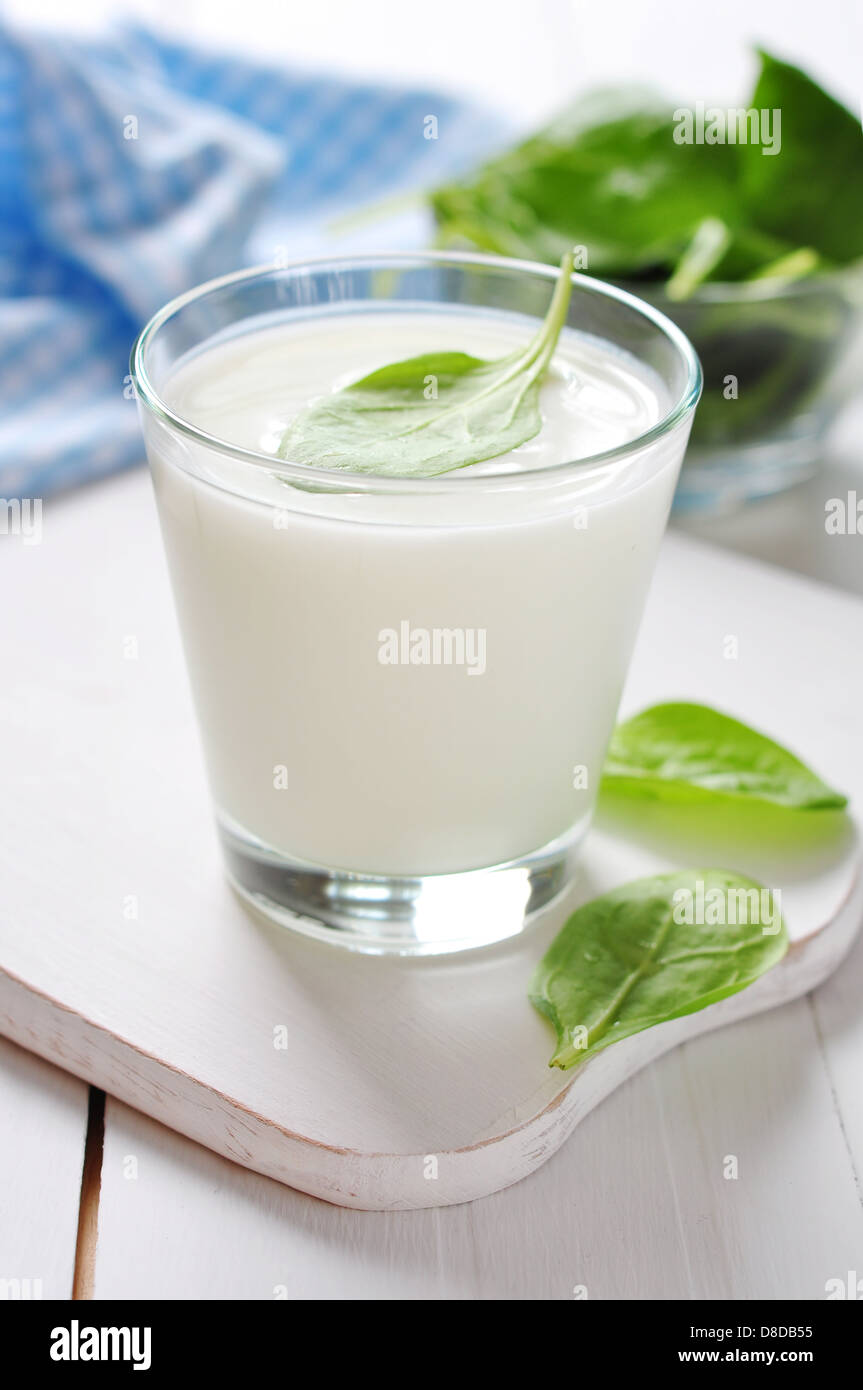 Yogurt with spinach in a glass on wooden cutting board Stock Photo