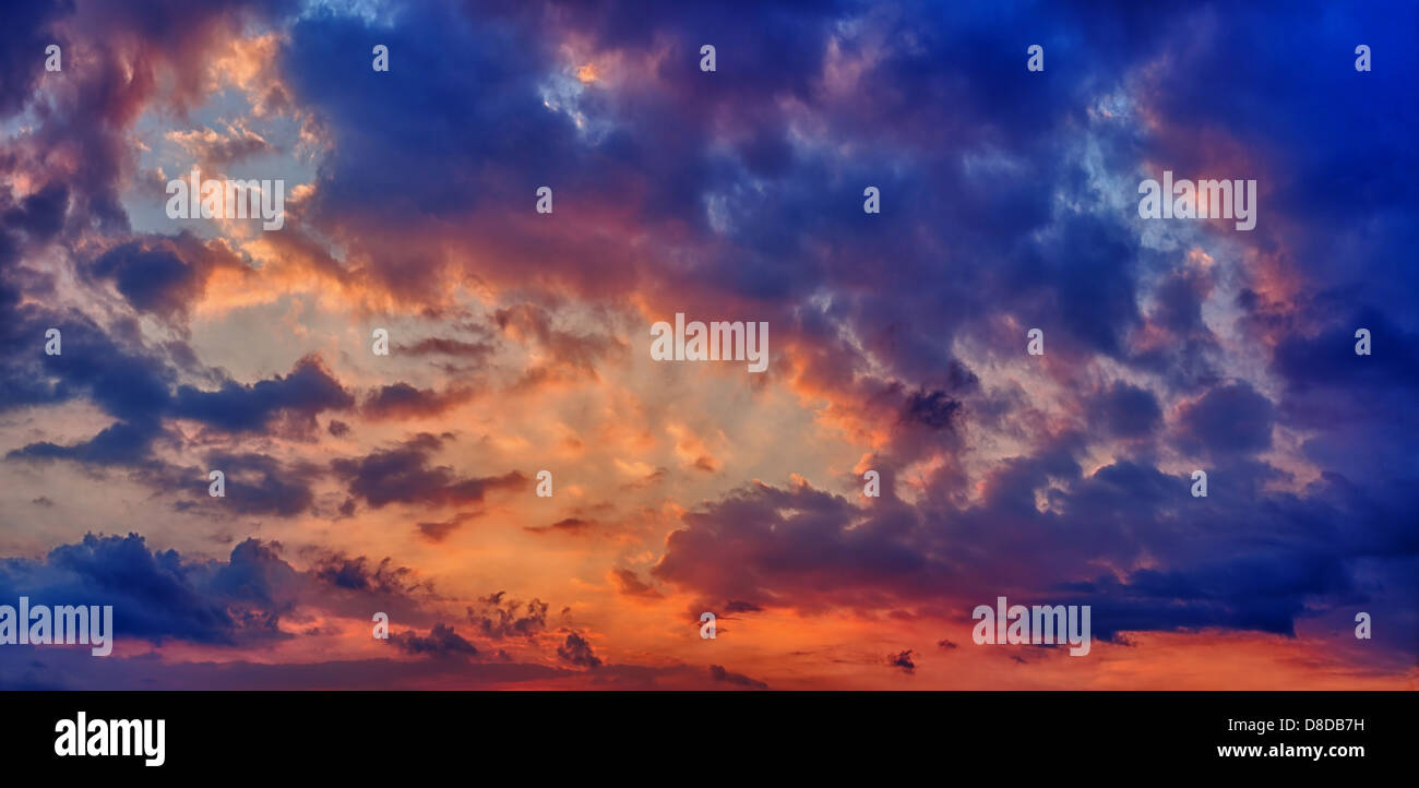 Sunset or sunrise with clouds. Panorama in dark blue and orange colors Stock Photo