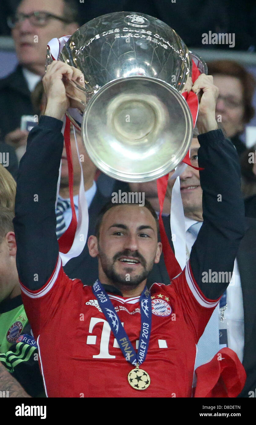 London, UK. 25th May, 2013. Diego Contento of Bayern Munich celebrates with  the trophy after winning the UEFA soccer Champions League final against  Borussia Dortmund at Wembley stadium in London, England, 25