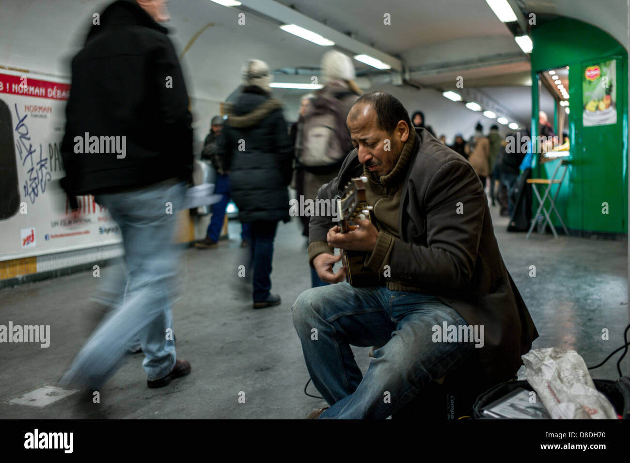 Busker playing guitar in Paris Metro. Stock Photo