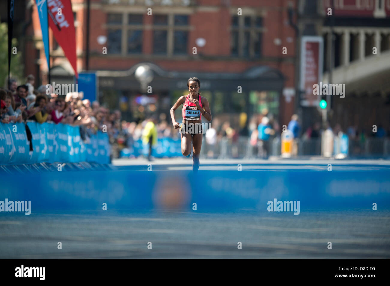 MANCHESTER, UK. 26th May 2013. Distance runner Tirunesh Dibaba of Ethiopia sprints alone towards the finish line of the 2013 Bupa Great Manchester Run to claim Womens 1st place in a time of 30mins 49secs in the 10km road event. The current 10,000m Olympic champion beat Latvia's Jeļena Prokopčuka into 2nd place by over a minute and a half. Credit: News Shots North/Alamy Live News (Editorial use only). Stock Photo