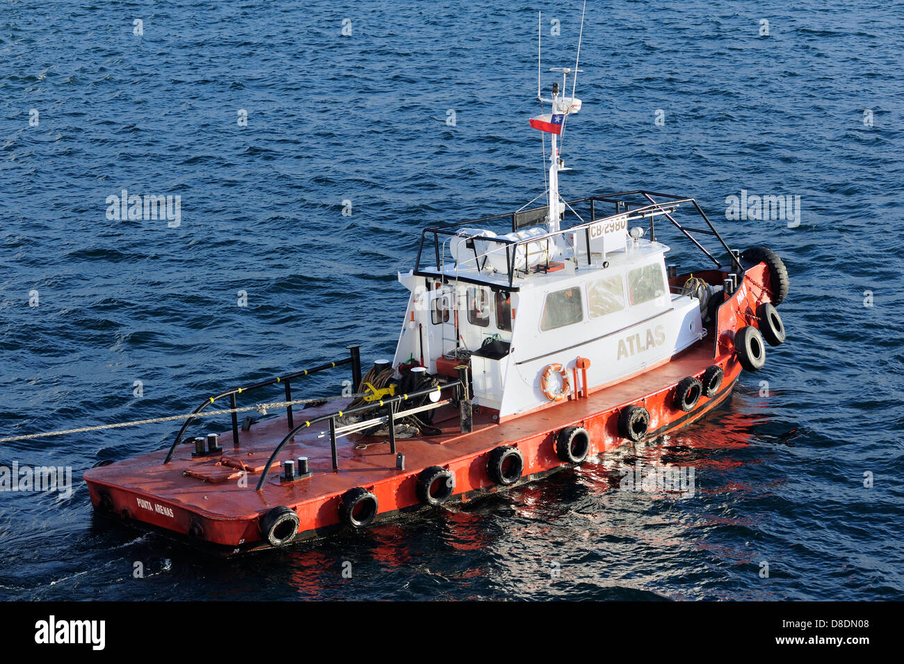 A tug tows a large ocean going fishing boat out of the harbour of Punta Arenas into  the  Strait of Magellan . Stock Photo