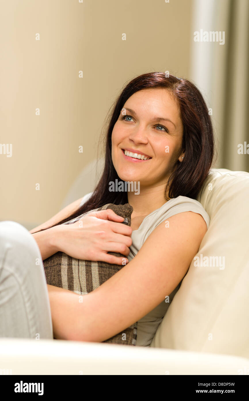 Joyful young woman sitting in armchair holding a pillow Stock Photo Alamy