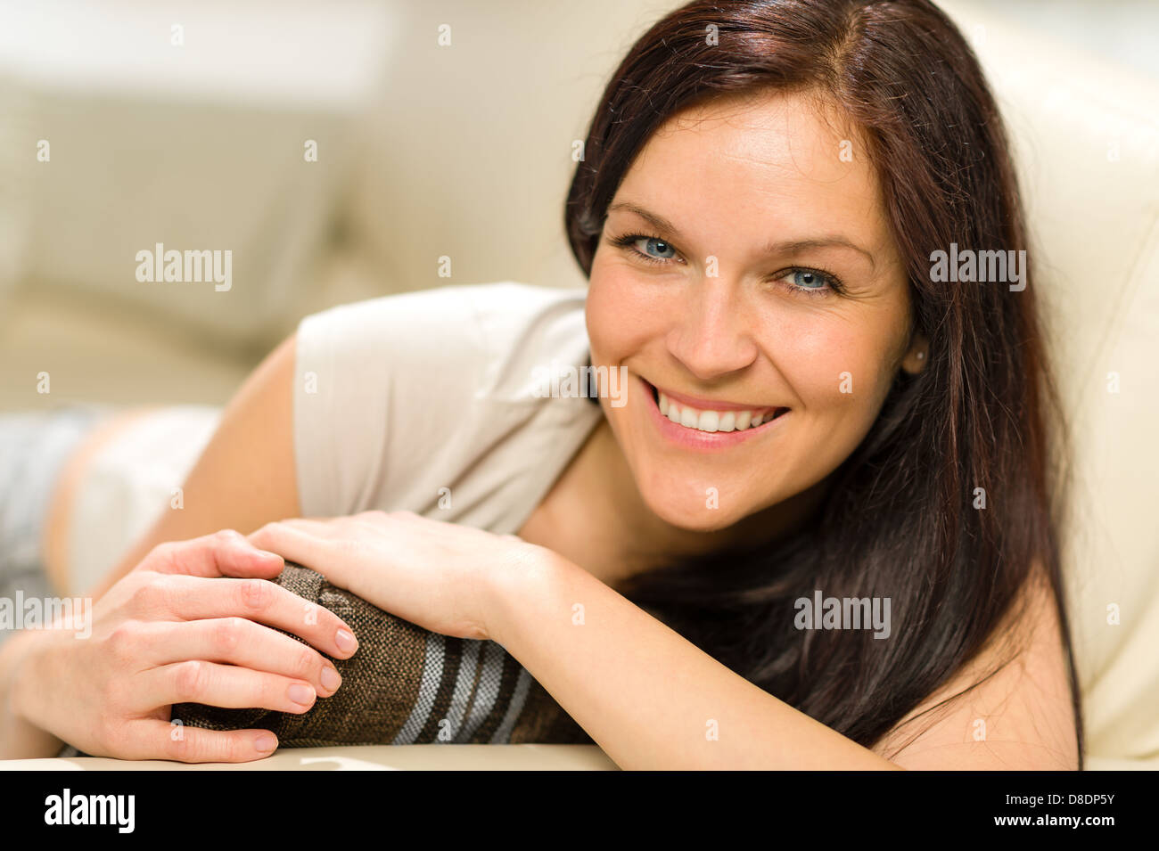 Serene cheerful woman lying on couch looking at camera Stock Photo - Alamy