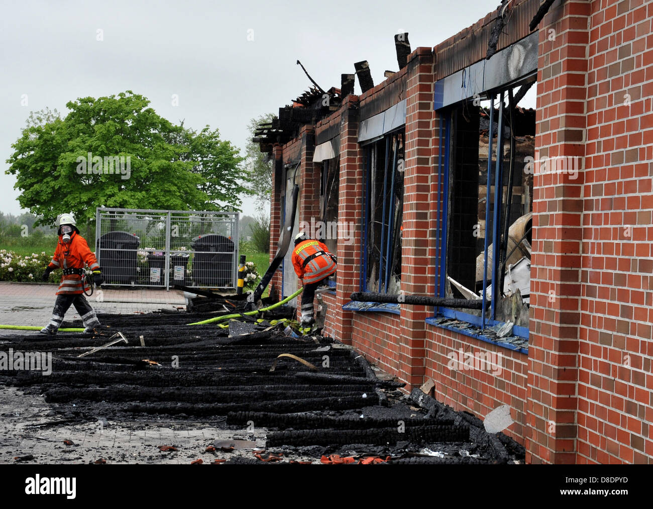 Firemen pick through the rubble of a fully burned out Lidl Supermarket