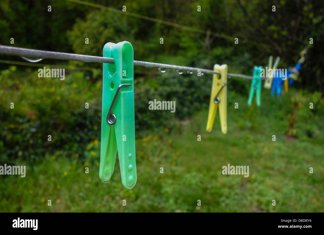 Colourful colorful plastic pegs hanging on washing line Stock Photo