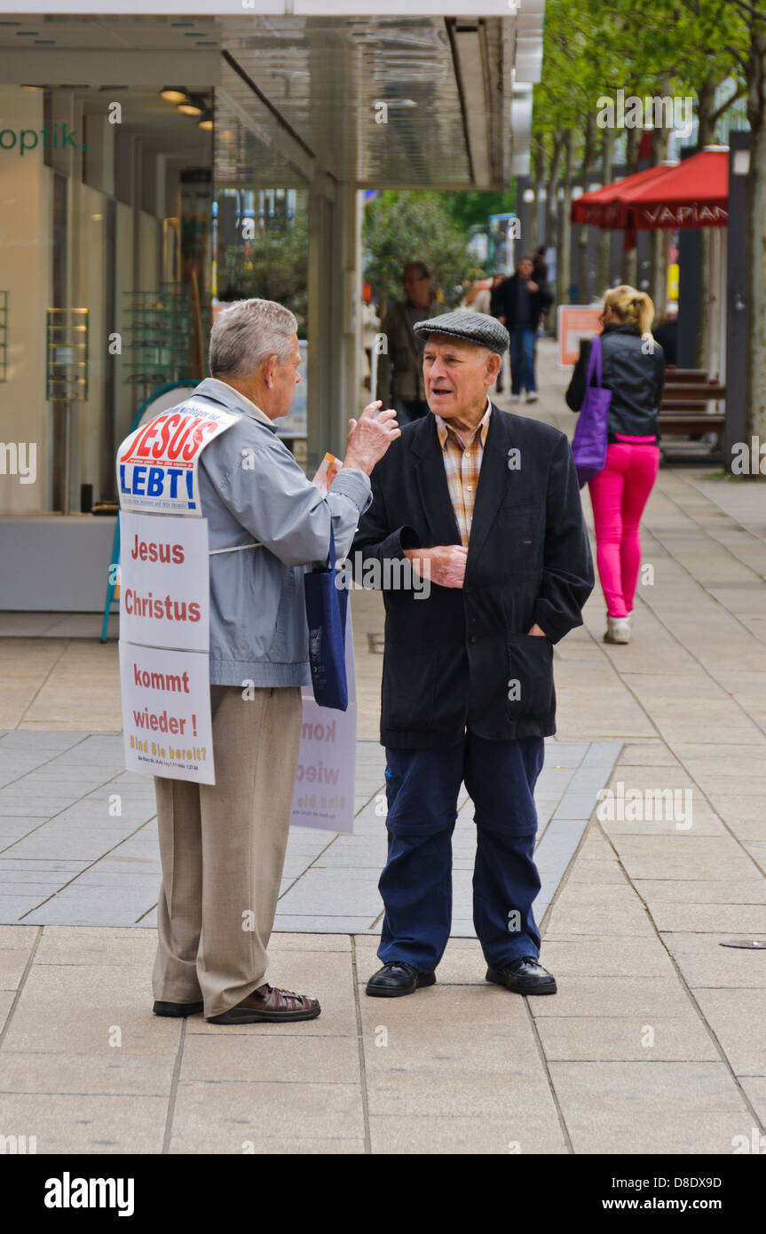 Old Christian missionary, preacher man, evangelizes a male senior citizen on the street – Heilbronn, Germany Stock Photo