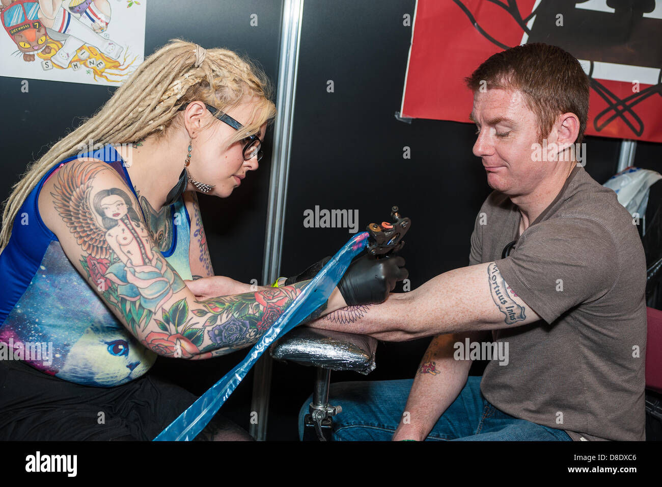 London, UK, 26th May 2013. Tattoo artist Ally Cat, 28 from Purley, Croydon works on a tattoo for Steve Dowling, 38, a food market worker from Henley-on-Thames Credit: Terence Mendoza/Alamy Live News Stock Photo