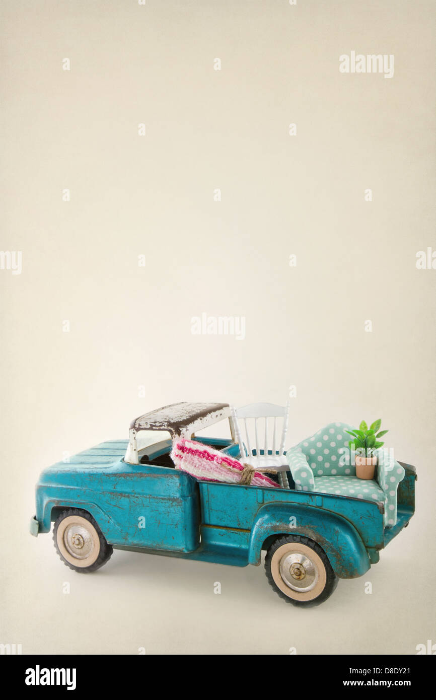 Old vintage toy truck packed with furniture - moving houses concept and copy space Stock Photo