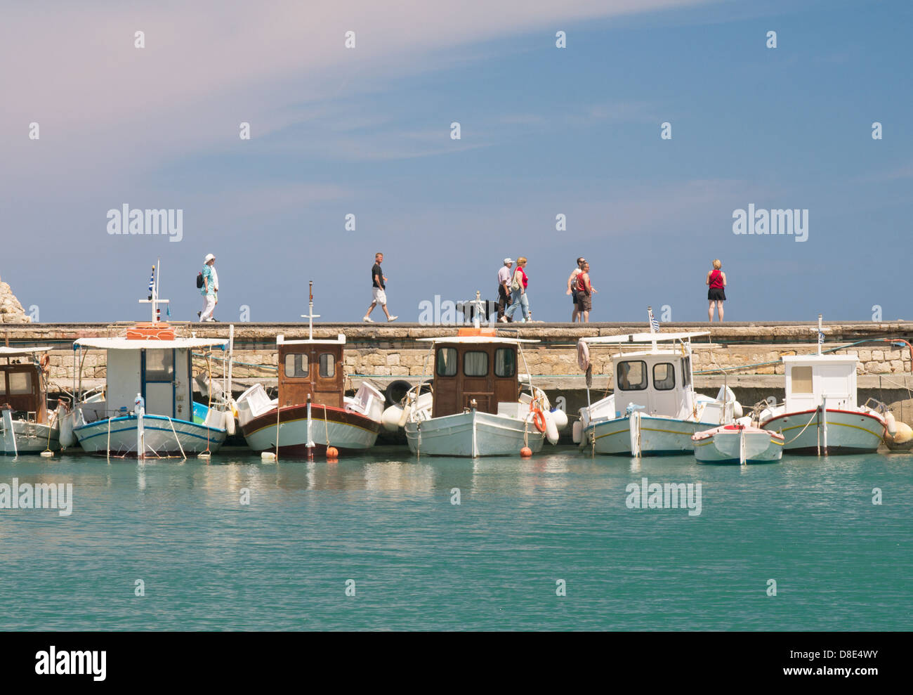 People walking along the harbour wall Heraklion, Crete, Greece Stock Photo