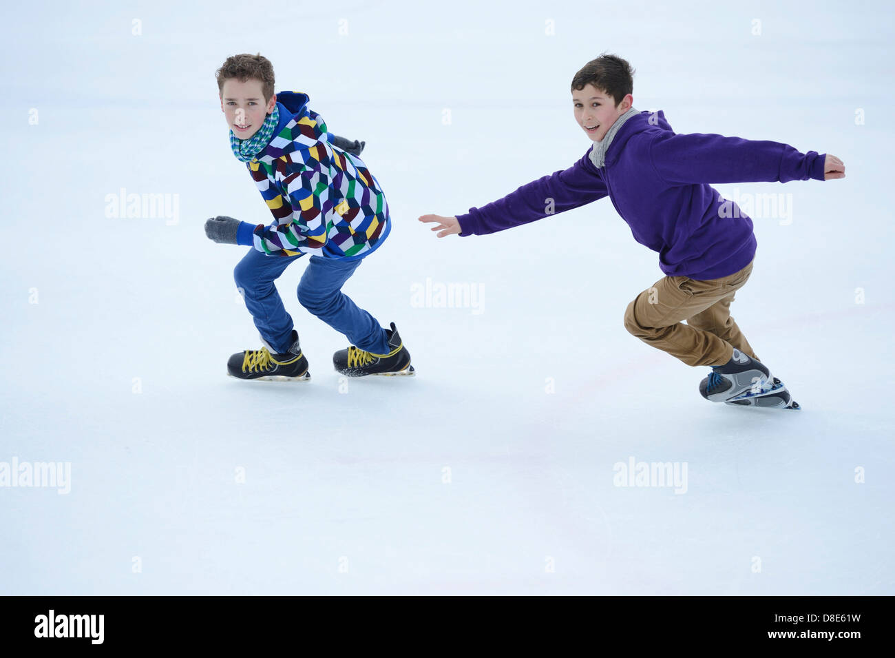 Two boys iceskating on a frozen lake Stock Photo Alamy