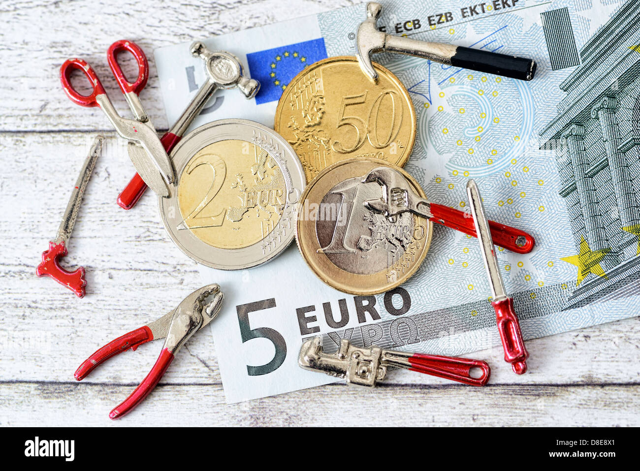 Euro coins with tools Symbolfoto 8,50 EUR minimum wage Stock Photo