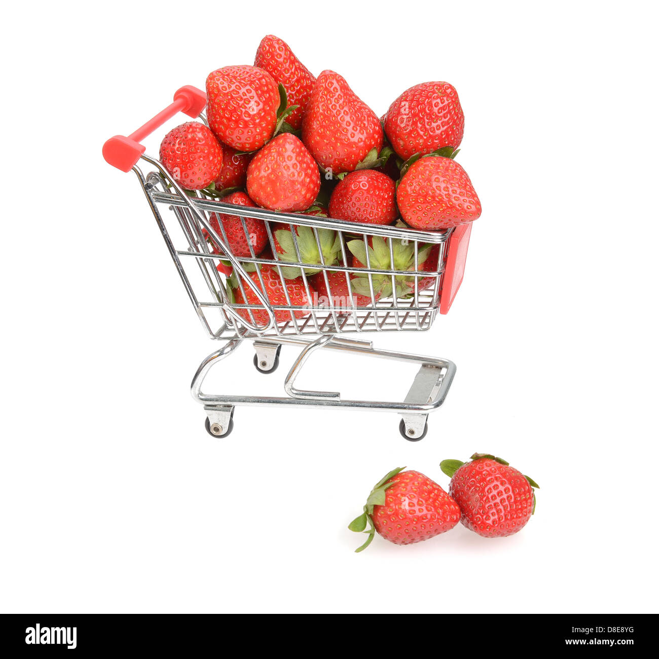 Shopping cart filled with fresh strawberries isolated over white Stock Photo
