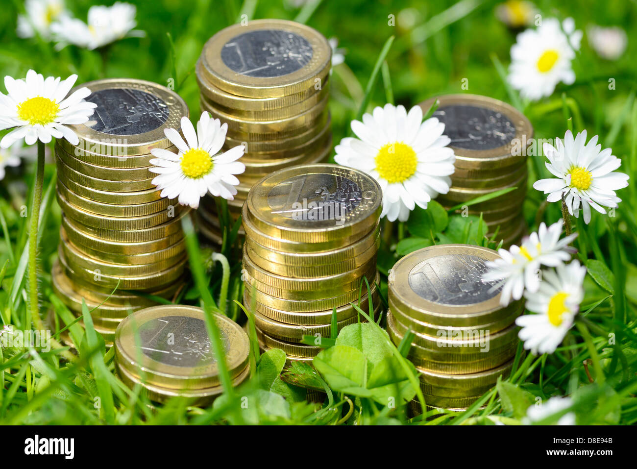 Piles of coins in the grass, investment Stock Photo