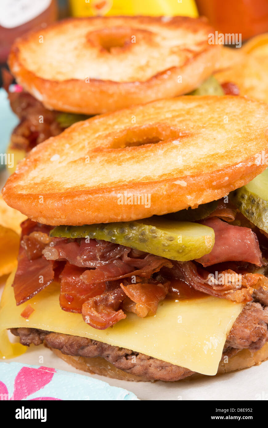 The Luther burger: a beef patty, cheese, crispy bacon and gherkins between two halves of a glazed ring doughnut. Stock Photo