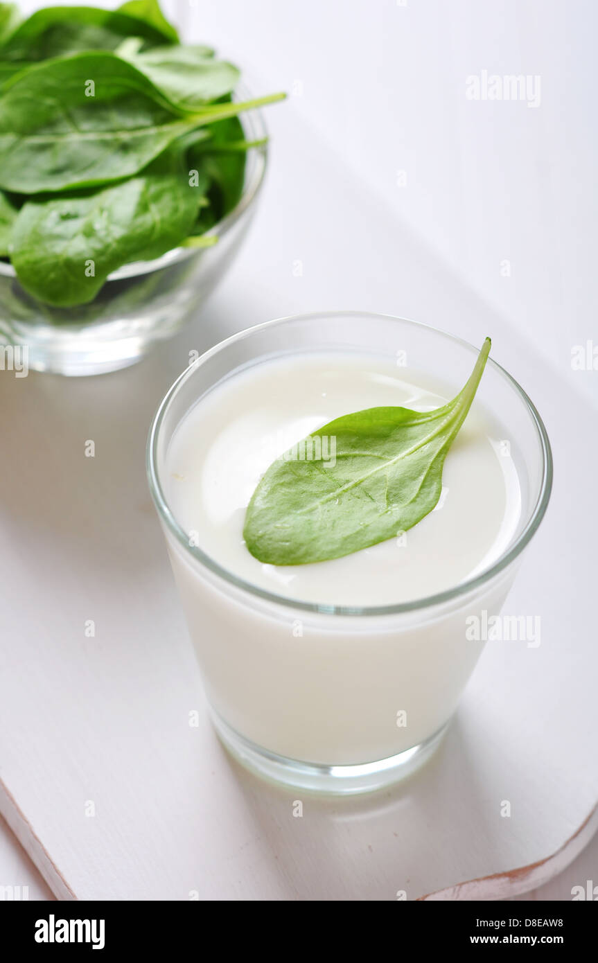 Yogurt with spinach in a glass on wooden cutting board Stock Photo