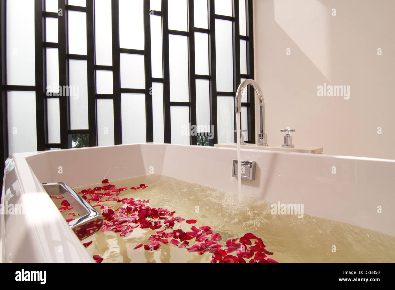 Luxury bath tub with water and flowers Stock Photo