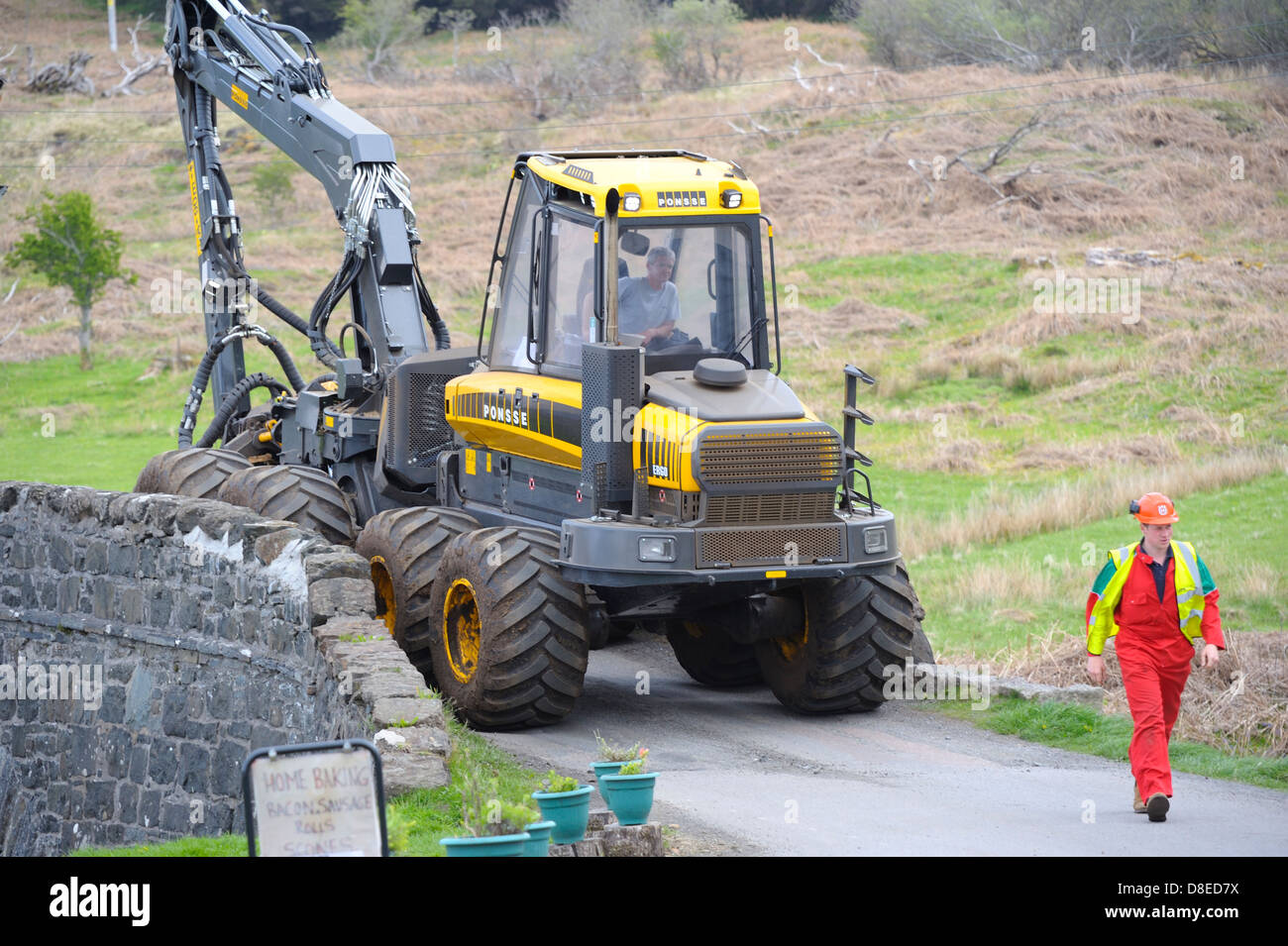 A large and heavy piece of timber logging  harvesting machinery being moved through a small village on the isle of mull. Stock Photo