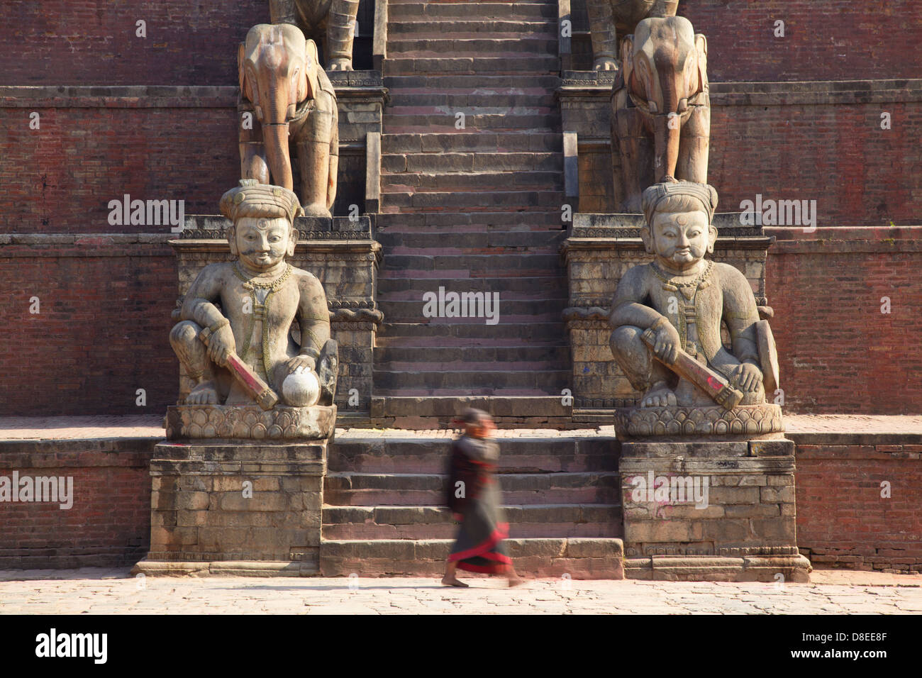 Woman walking past Nyatapola Temple, Taumadhi Tole, Bhaktapur (UNESCO World Heritage Site), Kathmandu Valley, Nepal Stock Photo