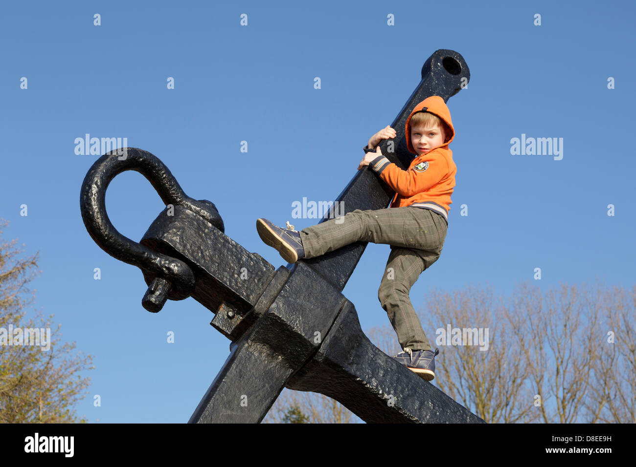 young boy climbing an anchor, Privall, Travemuende, Schleswig-Holstein, Germany Stock Photo