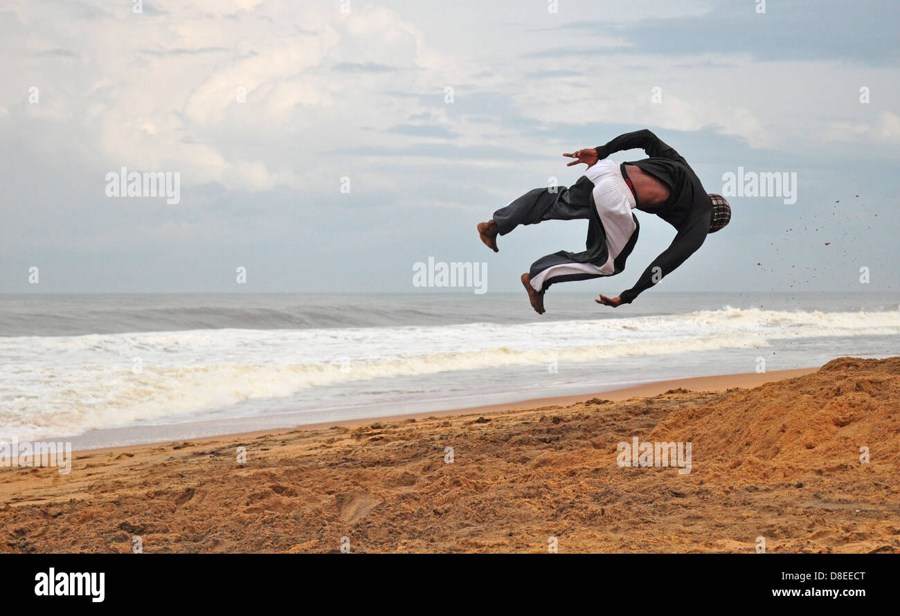 An acrobat performs on the beach Stock Photo
