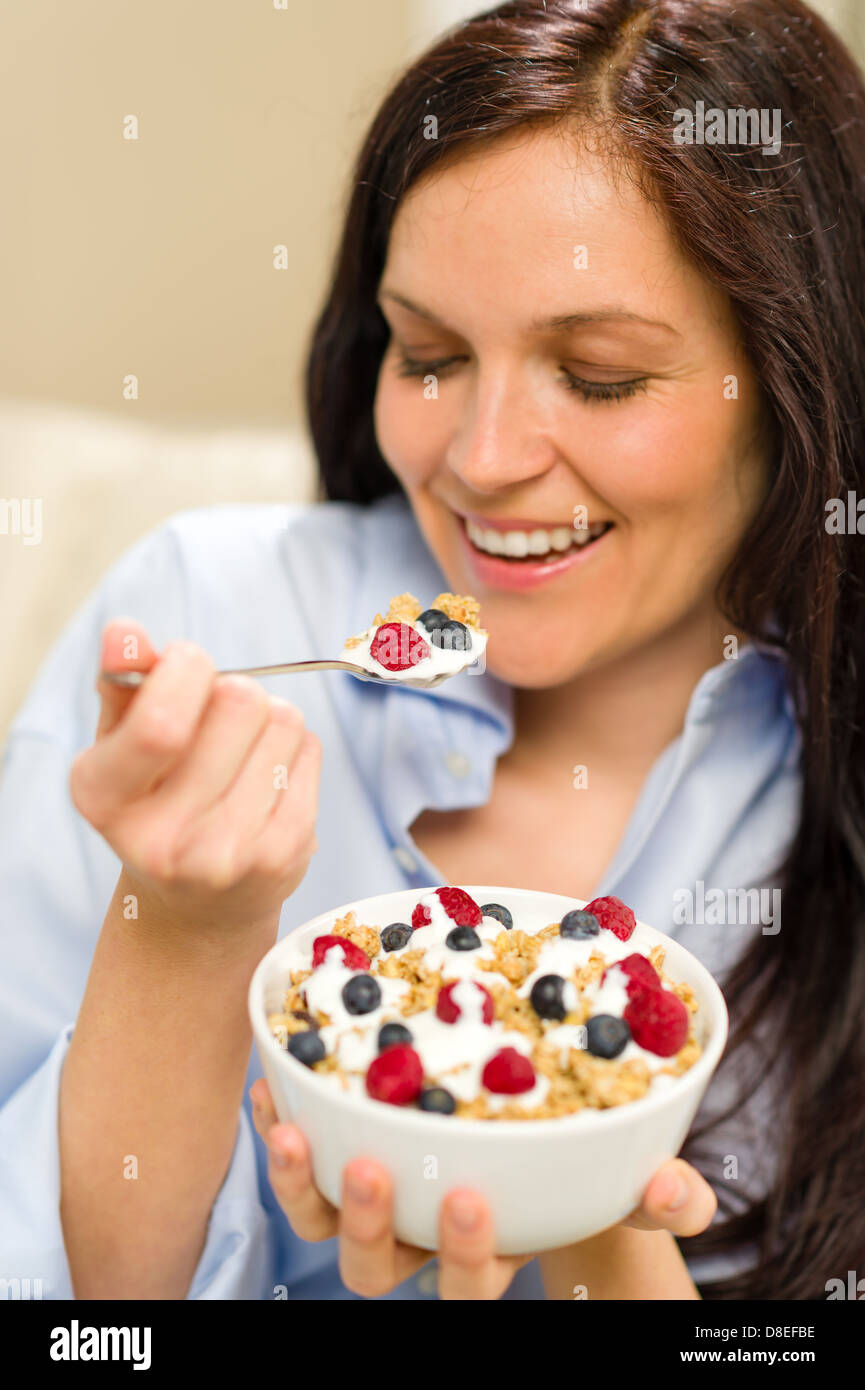 Dieting woman eating healthy cereal with yogurt for breakfast Stock