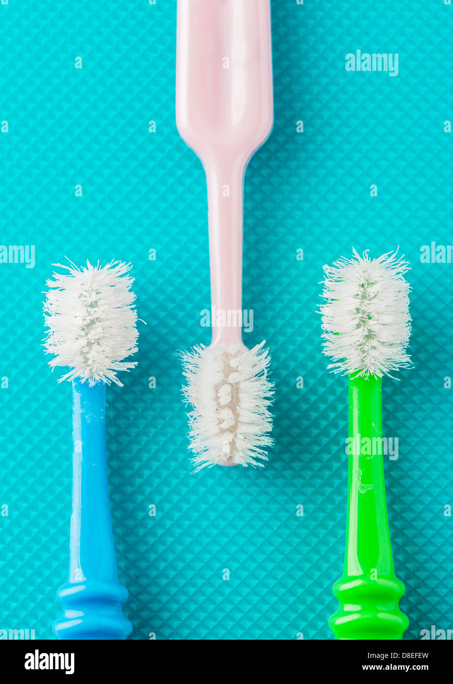 Closeup of three old and well used toothbrushes viewed from above Stock Photo