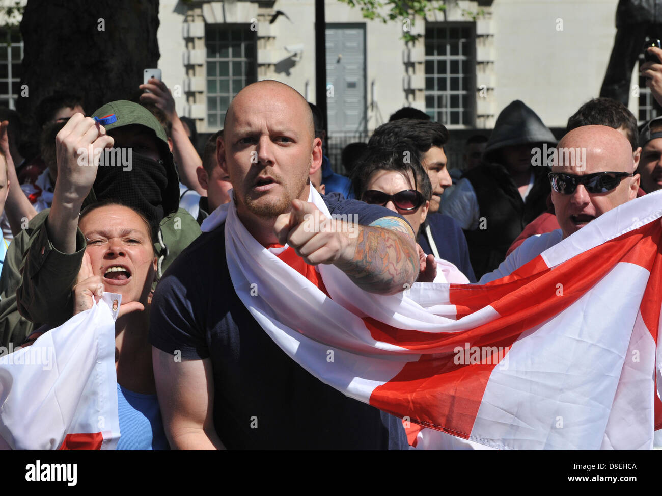 Whitehall, London, UK. 27th May 2013. Members of the EDL make their way towards Downing Street behind barriers and under police escort to seperate them from the counter demonstration. The EDL demonstration prompted by the death of Drummer Lee Rigby and a counter demonstration cause chaos on Whitehall as they move towards Downing Street. Credit: Matthew Chattle/Alamy Live News Stock Photo