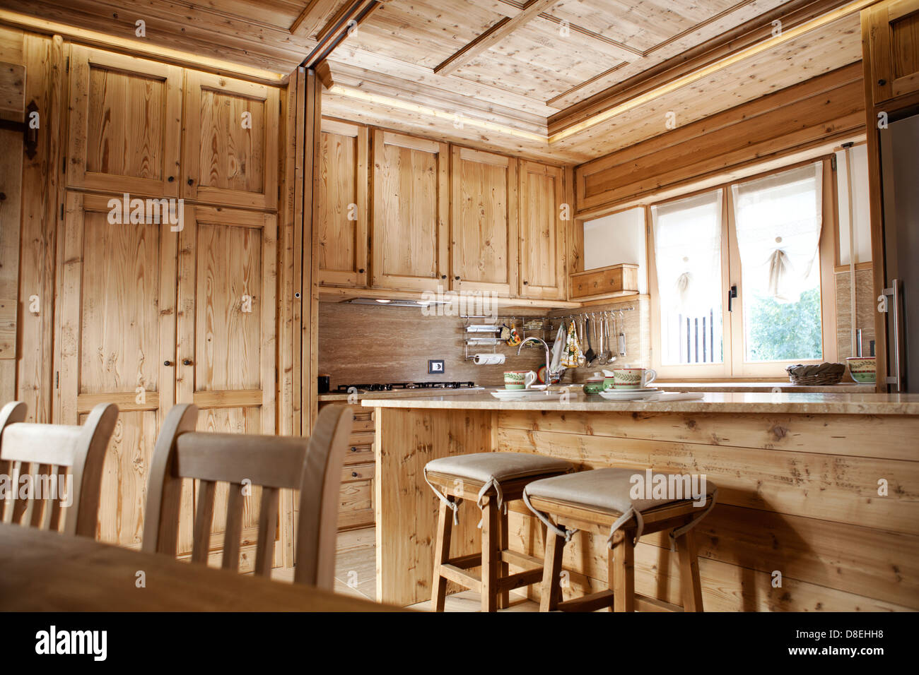 Natural wood finished alpine kitchen cabinets and table and chairs Stock Photo