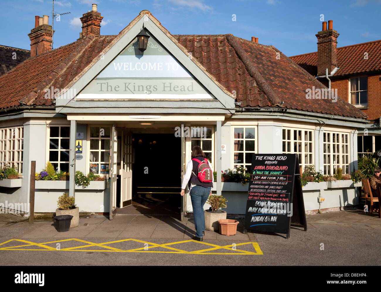 A woman entering the Kings Head pub, Wroxham, Norfolk UK Stock Photo