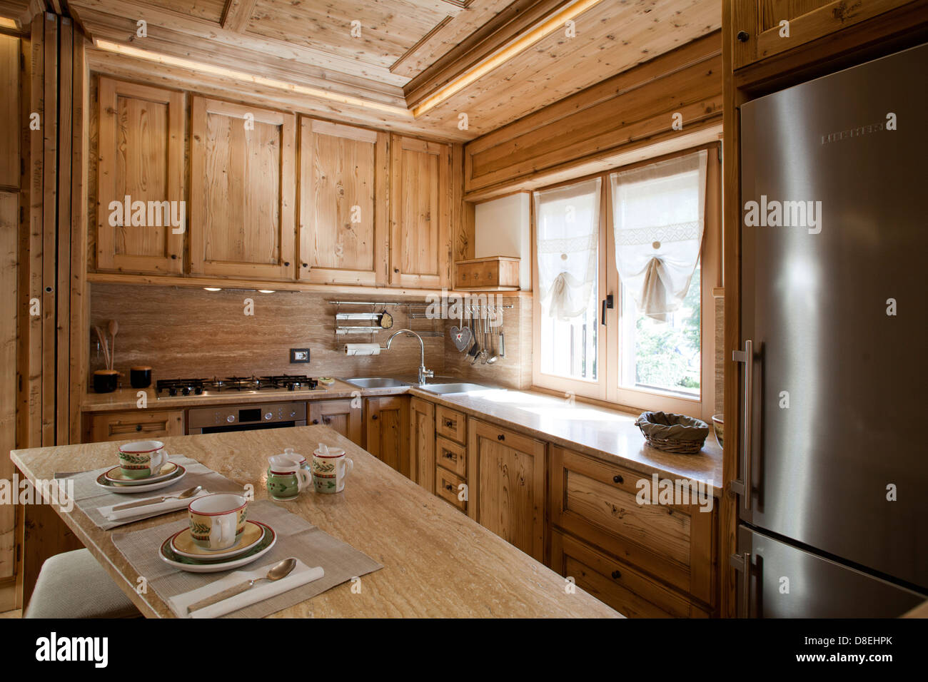 Alpine apartment. Pine tree wooden kitchen naturally finished Stock Photo