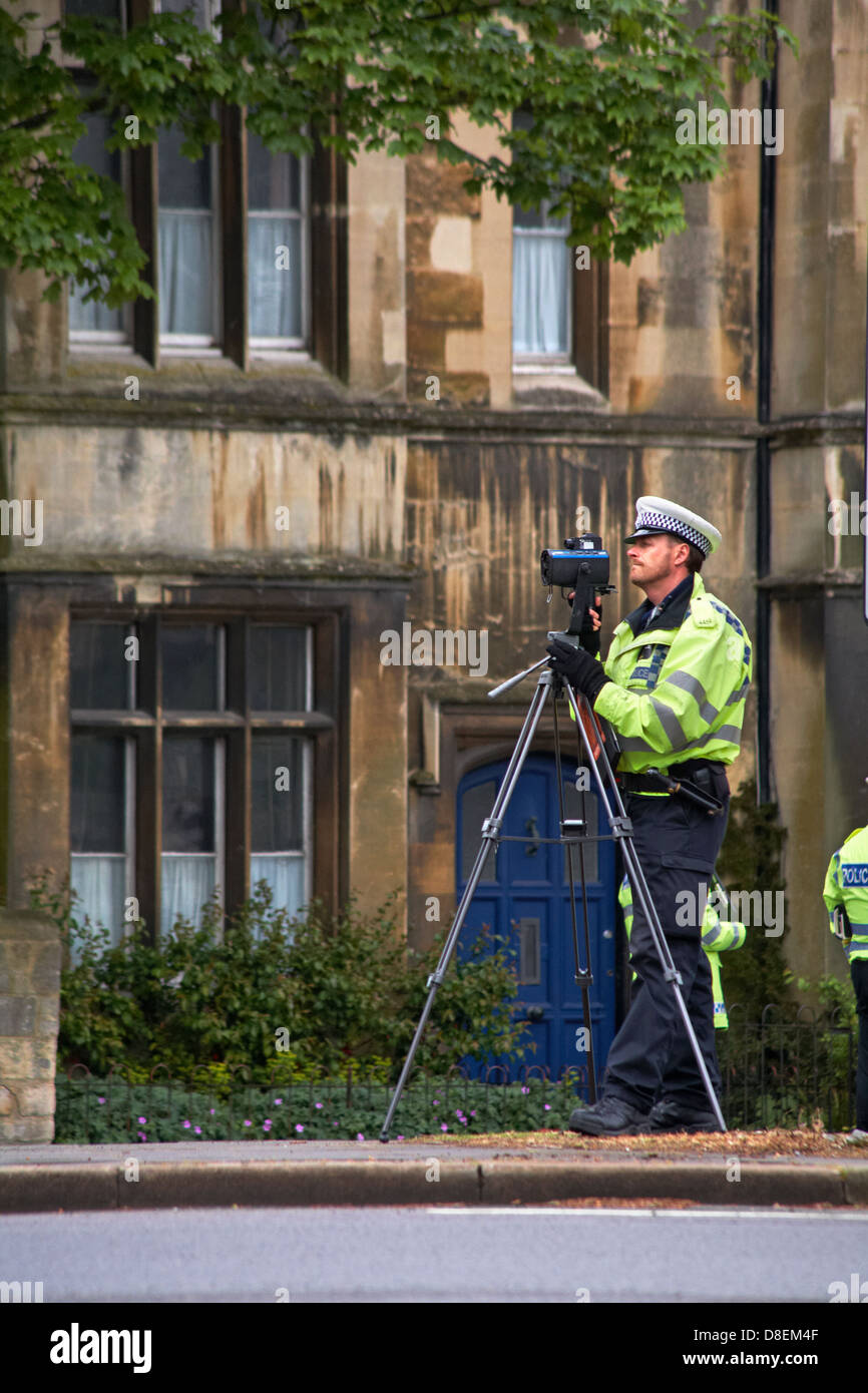 Traffic police officer with mobile speed camera on tripod checking