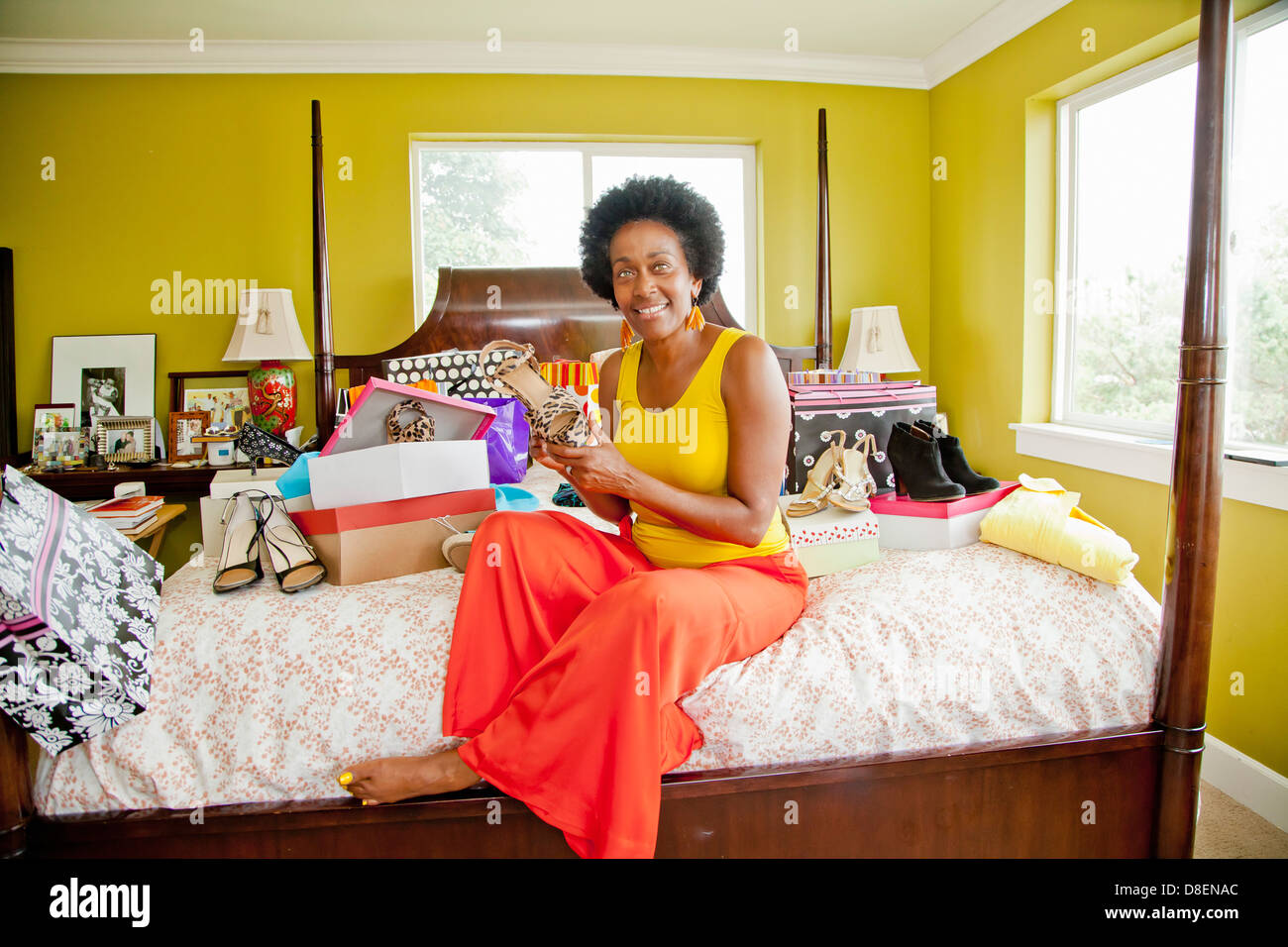 Woman on bed with shopping bags and shoes Stock Photo