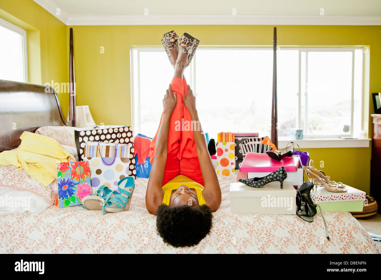 Woman on bed with shopping bags and shoes Stock Photo