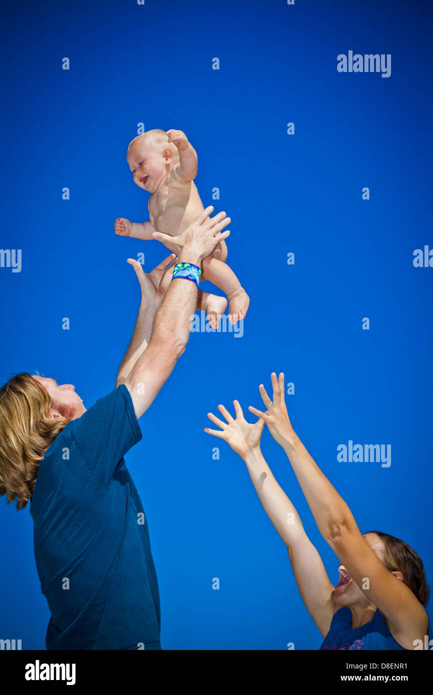 Parents holding baby up in air Stock Photo